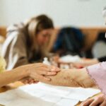 Caregiver gently supporting an elderly woman's arm while walking, helping prevent falls at home