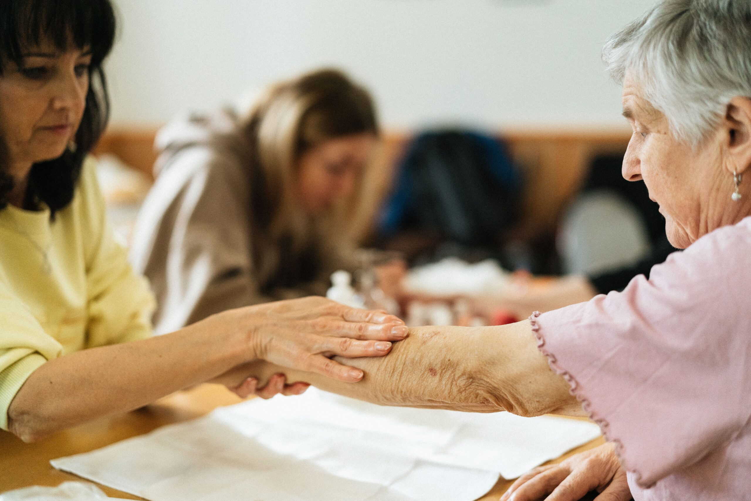 A caregiver gently supporting an elderly woman while walking together at home in Burleson, TX