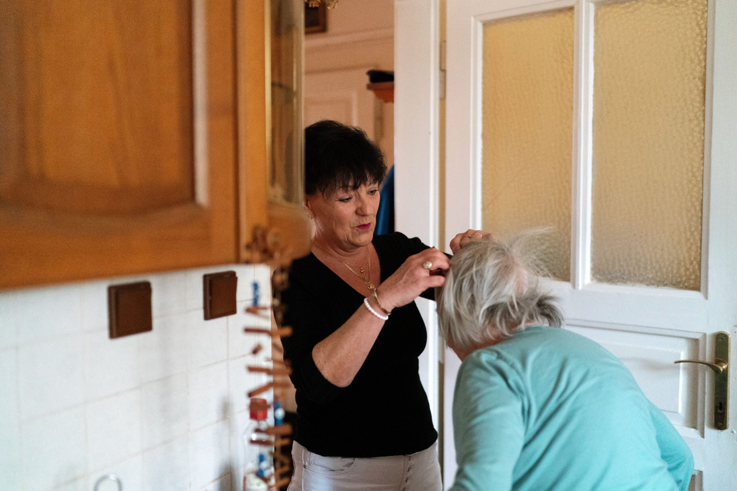 Professional in-home caregiver assisting a senior woman, representing the kind of trained, vetted care a licensed agency provides