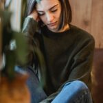 A woman taking a peaceful, quiet break by a window at home, representing the rest and recharge time respite care provides for family caregivers