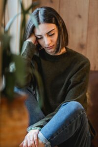 A woman taking a peaceful, quiet break by a window at home, representing the rest and recharge time respite care provides for family caregivers