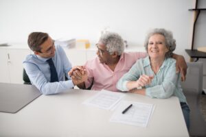 A senior couple meeting with a consultant, discussing questions and documents, representing the kind of informed conversation families should have before choosing a home care agency